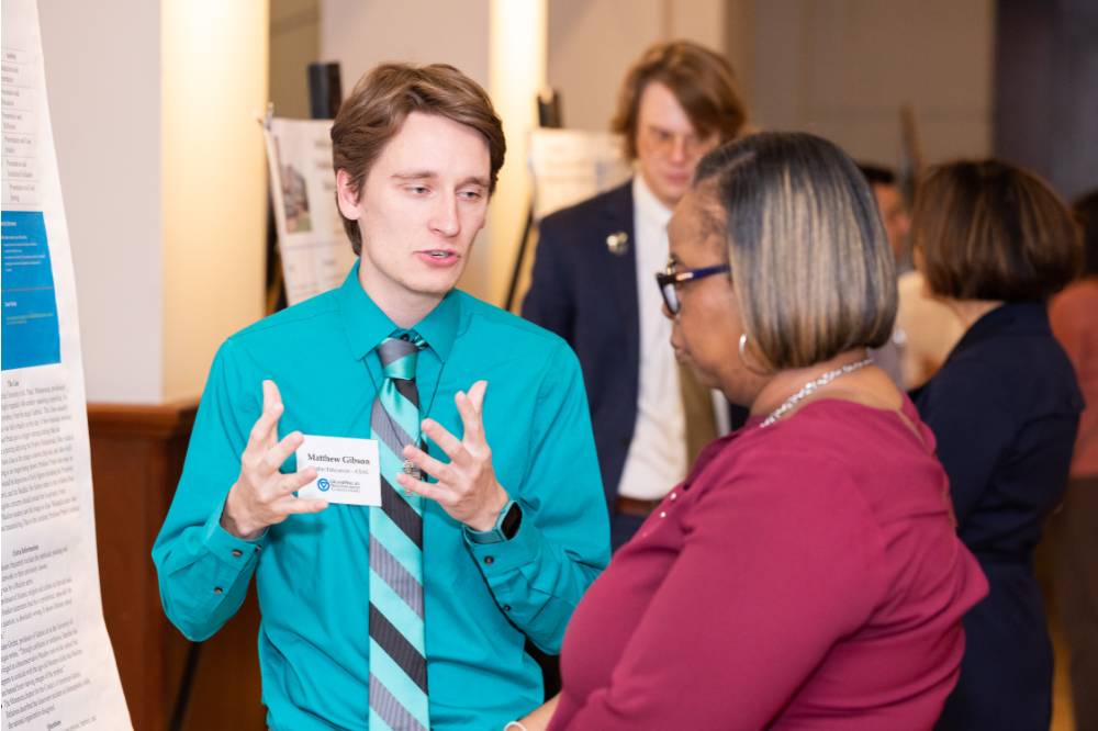 Matthew (left) speaking with a guest (right).